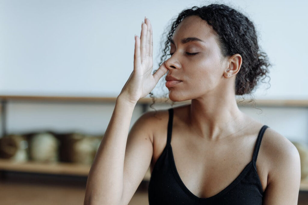 Woman practicing deep breathing a technique used for anxiety reduction.