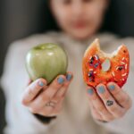 woman showing apple and bitten doughnut symbolizing how to break a habit in 21 days