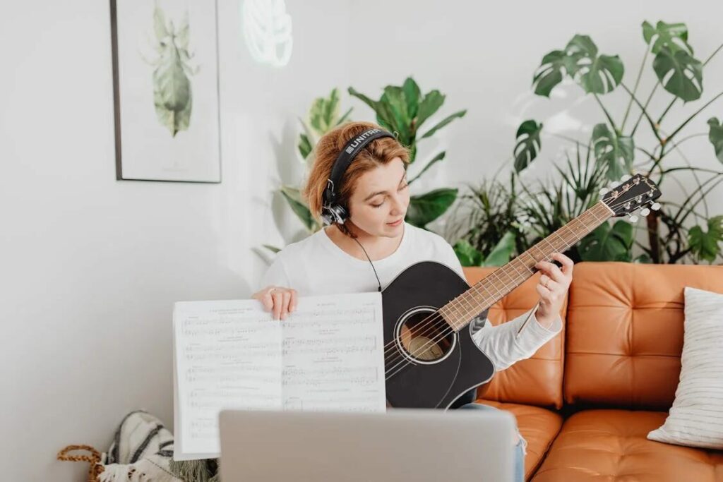 woman learning how to play a guitar representing hobby ideas and how to find a hobby you like