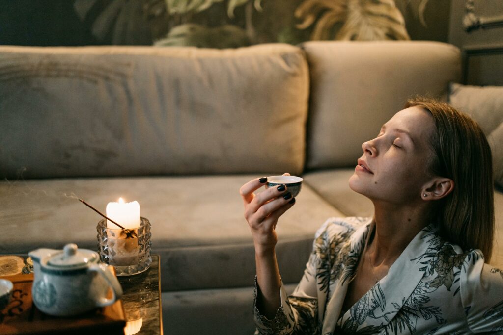 woman relaxing with a cup of tea in the hand representing an empowering evening routine
