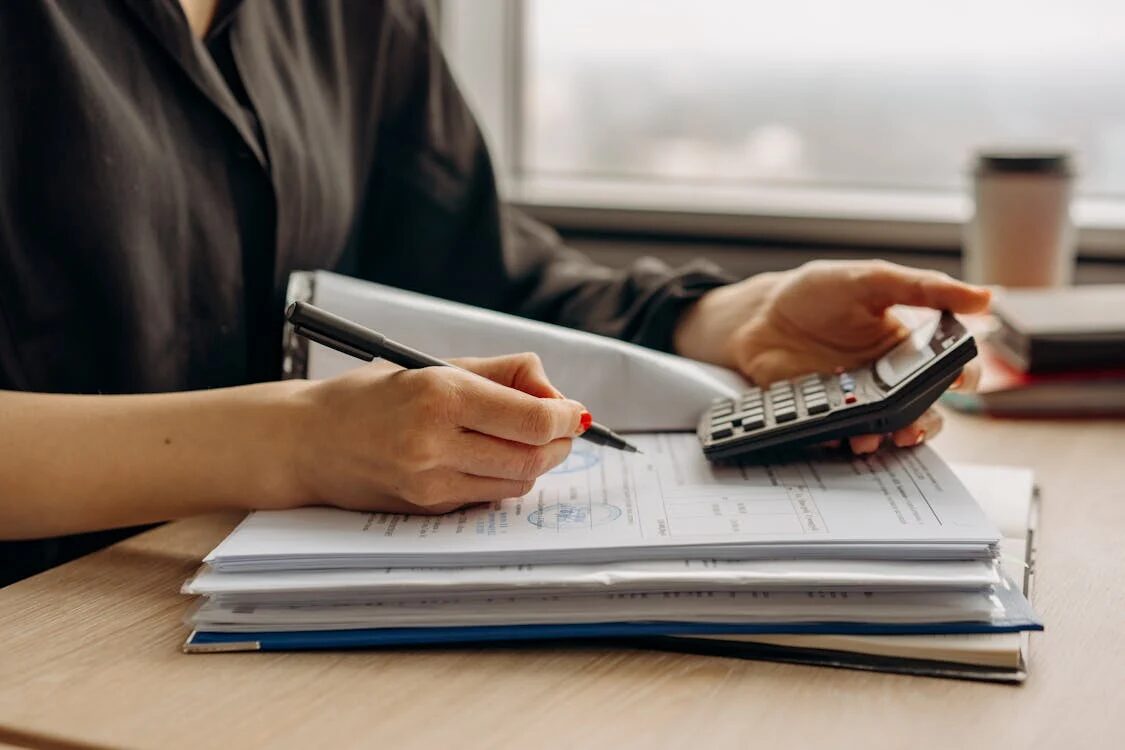 woman with a calculator and a pen symbolizing someone learning about personal finance for beginners