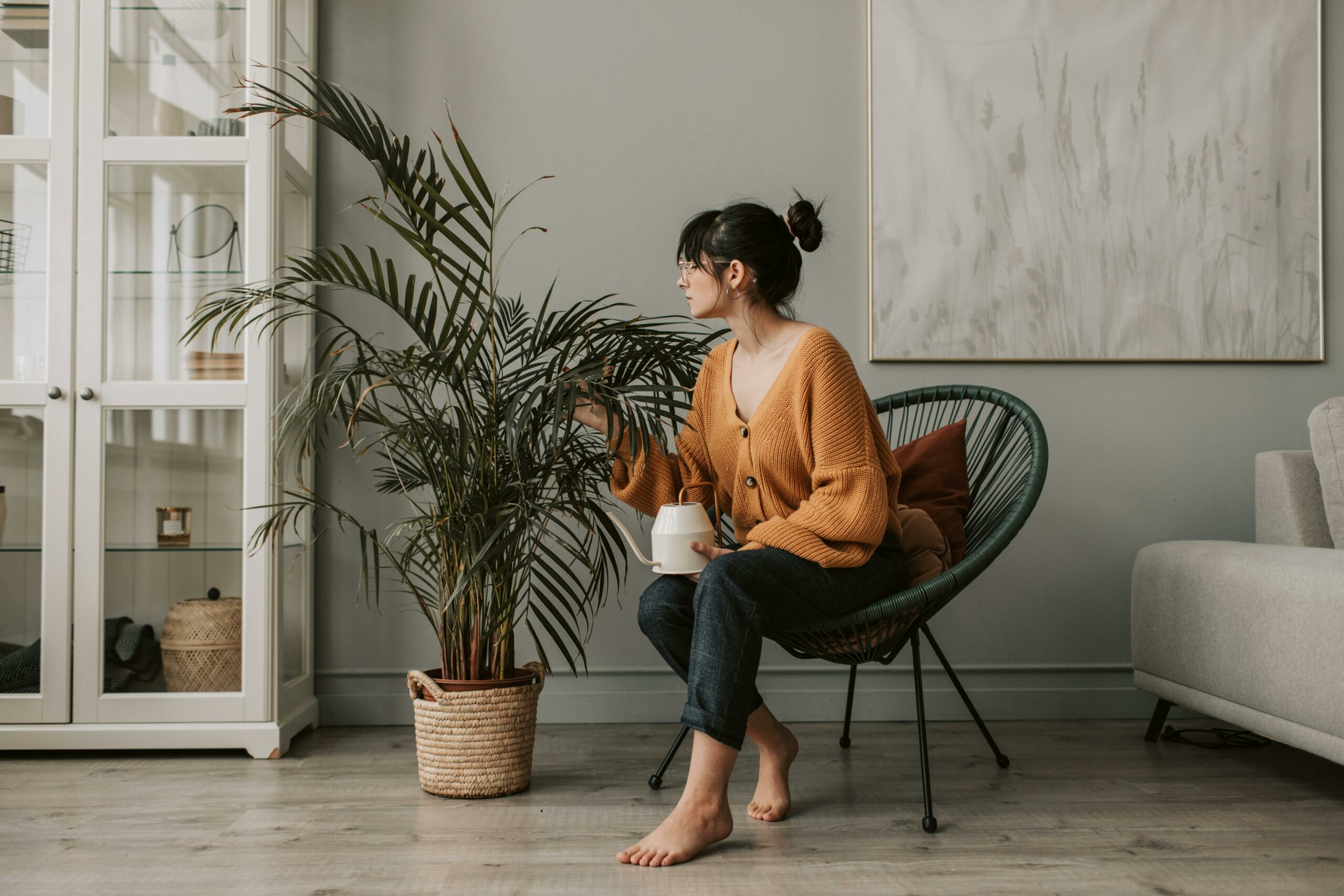 woman looking at indoor plant representing how indoor plants an bring positive energy to your house