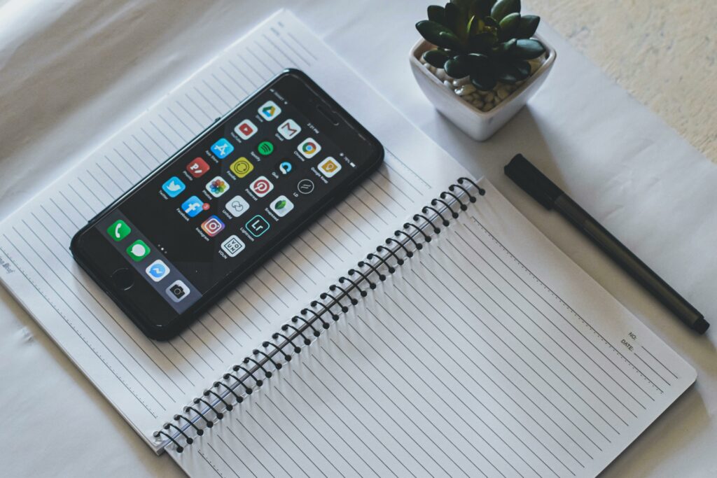 phone on top of a notebook representing journaling apps