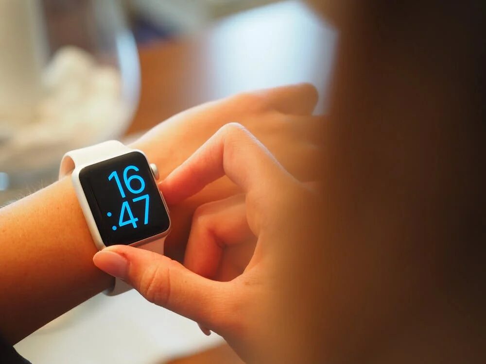 Woman checking time on her Apple Watch, symbolizing procrastination and time management challenges